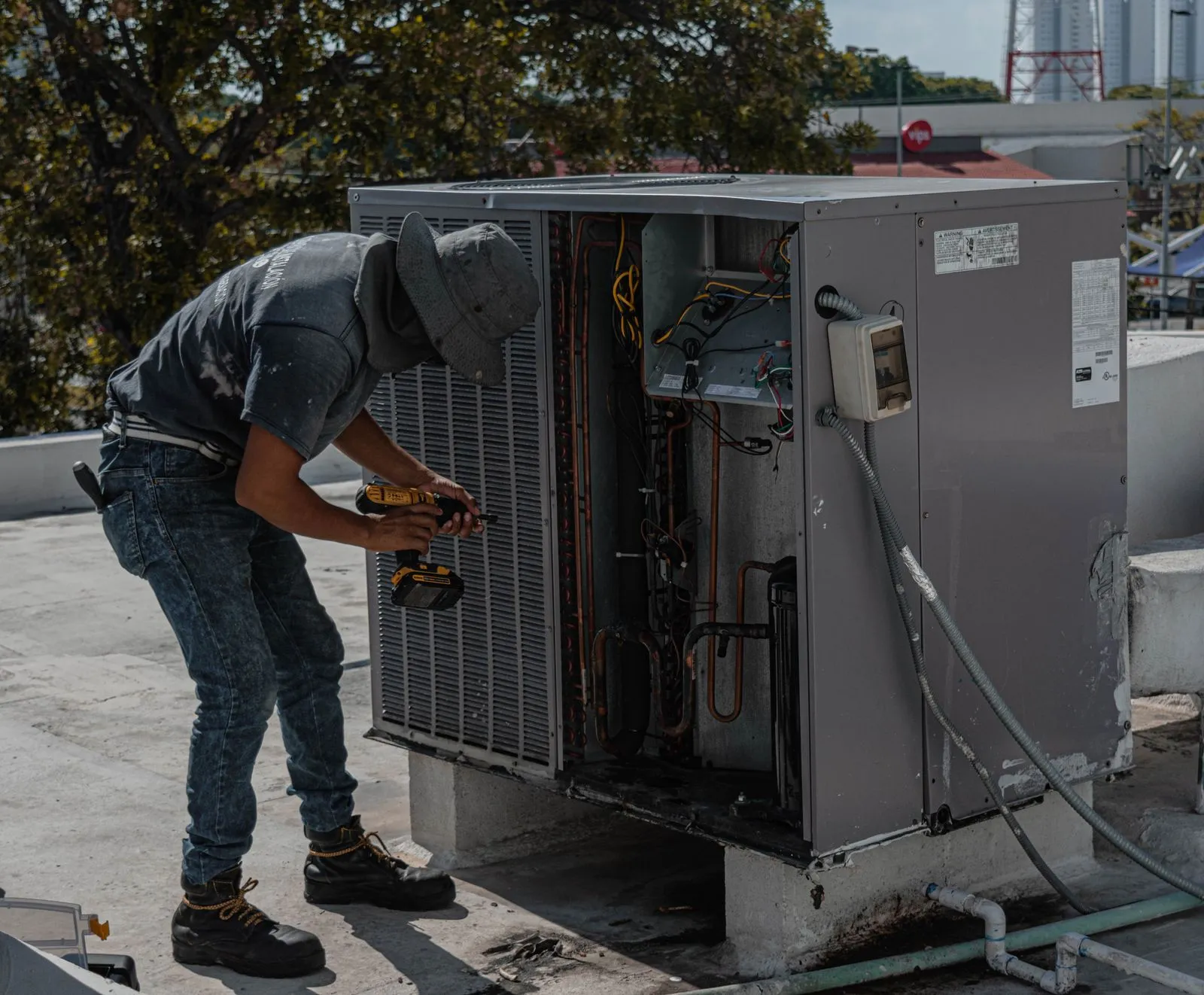 AC Repair Company Cave Creek AZ — worker repairing an outdoor air conditioning unit on a roof